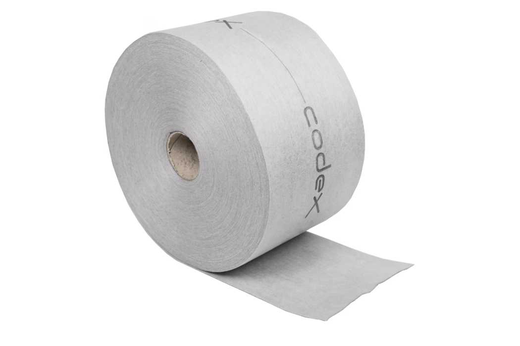 codex_Dummy_DB 140 Slim_2020-03 Close-up of a large gray toilet paper roll with a visible cardboard core and one sheet unrolled; the paper shows a faint printed logo along the outer edge.