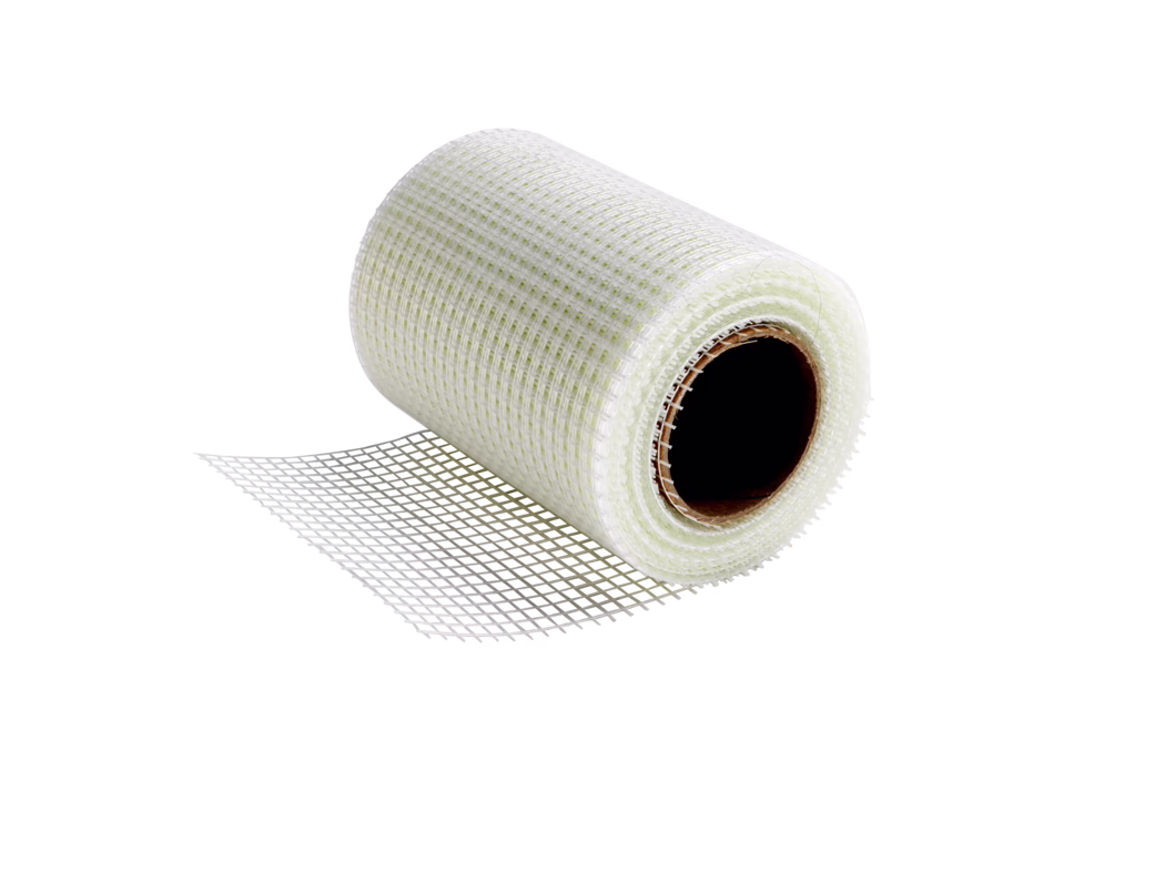 codex_Dummy_X-Board reinfo.tape_2022-05 Close-up of a roll of white fiberglass mesh with a visible cardboard core on a white background; the mesh shows a square grid pattern and is partially unrolled, casting a soft shadow, with texture and translucent fibers clearly visible.